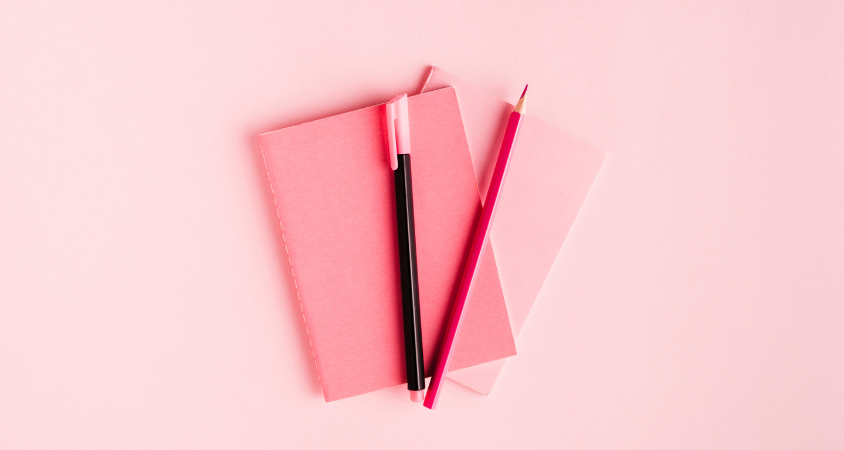 pink background, notebook, pen, crayon